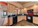 This kitchen has light wood cabinets, black appliances, and a decorative backsplash and tile floors at 1523 Silver Point Ave, Las Vegas, NV 89123