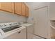 Functional laundry room with modern washer and dryer, upper cabinets, and tile flooring at 1523 Silver Point Ave, Las Vegas, NV 89123