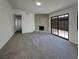 Bright living room featuring a stone fireplace, plush gray carpet, and sliding glass doors to a patio at 1832 Yellow Rose St, Las Vegas, NV 89108