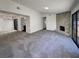 Spacious living room with a stone fireplace, plush gray carpet, and natural light from large windows at 1832 Yellow Rose St, Las Vegas, NV 89108