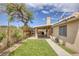This backyard features a covered patio, green turf, mature trees, and a charming lattice fence at 1845 Candle Bright Dr, Henderson, NV 89074
