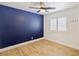 Bright bedroom with wood floors, a ceiling fan, and a navy accent wall at 1845 Candle Bright Dr, Henderson, NV 89074