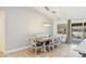 An open dining room with a modern light fixture and a dark wood table with seating for six at 1845 Candle Bright Dr, Henderson, NV 89074