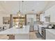 Bright kitchen features white cabinets, stainless appliances, island with stone counters and a door to the backyard at 1845 Candle Bright Dr, Henderson, NV 89074