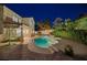 Gorgeous backyard features a pool with spa and mature landscaping at dusk at 1921 Spyglass Dr, Henderson, NV 89074