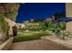 Backyard featuring a putting green, lush landscaping, an outdoor dining set and a covered patio area at 1921 Spyglass Dr, Henderson, NV 89074