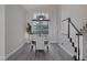 Elegant dining room with stylish lighting, seating for six, and staircase access at 1921 Spyglass Dr, Henderson, NV 89074