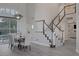 Elegant dining area with stylish lighting, seating for six, and staircase access at 1921 Spyglass Dr, Henderson, NV 89074