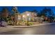 Inviting two-story home with desert landscaping, exterior lighting and a two car garage at twilight at 1921 Spyglass Dr, Henderson, NV 89074