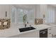 Kitchen sink area featuring quartz countertops, black sink and faucet, and bay window with shutters at 1921 Spyglass Dr, Henderson, NV 89074