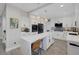 Bright kitchen featuring white cabinetry, an island with waterfall countertops, and stainless steel appliances at 1921 Spyglass Dr, Henderson, NV 89074