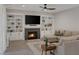 Cozy living room with fireplace, custom bookshelves, and neutral-toned furnishings at 1921 Spyglass Dr, Henderson, NV 89074