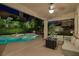 Covered patio features comfortable seating, a fire pit, and views of the pool and landscaped yard at 1921 Spyglass Dr, Henderson, NV 89074