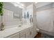 Charming bathroom with white cabinetry, a framed mirror, wood-look floors and a shower tub combination at 1951 Jim Haworth Ct, Logandale, NV 89021