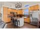 Well-lit kitchen boasts wooden cabinets, stainless steel appliances, and an island with bar seating at 1951 Jim Haworth Ct, Logandale, NV 89021