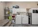 Functional laundry area with washer, dryer, water heater, sink, and storage cabinets, offering efficiency at 1951 Jim Haworth Ct, Logandale, NV 89021