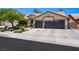 Attractive single-story home with desert landscaping and a spacious driveway leading to a three-car garage at 211 Kokopelli Ct, Henderson, NV 89074