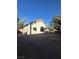 A spacious backyard featuring gravel landscaping, a stucco home, and a second story balcony at 2306 Jared Ct, North Las Vegas, NV 89032