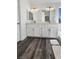 Bright bathroom with a double sink vanity and modern fixtures over dark wood-look floors at 2306 Jared Ct, North Las Vegas, NV 89032