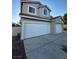Two-car garage with a double wide door and a single car door, complimented by a well-manicured yard at 2306 Jared Ct, North Las Vegas, NV 89032