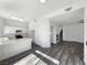 Open-concept kitchen with white cabinets, quartz countertops, stainless steel appliances, and wood-look flooring at 2306 Jared Ct, North Las Vegas, NV 89032
