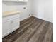Well-lit laundry room featuring stylish wood-look flooring, bright white cabinets, and a practical beige countertop at 2306 Jared Ct, North Las Vegas, NV 89032