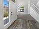 Bright living room featuring large windows, a staircase, and stylish wood-look flooring at the entrance at 2306 Jared Ct, North Las Vegas, NV 89032