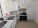 Compact kitchen featuring white cabinets, a stainless-steel range, and tile backsplash at 255 S 17Th St, Las Vegas, NV 89101