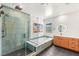 Bathroom featuring a spacious shower, soaking tub, modern vanity, and eye-catching tile at 2578 Skylark Trail St, Henderson, NV 89044
