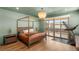 Light-filled bedroom features four-poster bed, chandelier, and sliding doors to a balcony at 2578 Skylark Trail St, Henderson, NV 89044