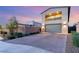 A modern home with a spacious driveway, two-car garage, balcony, neutral color palette, and manicured greenery at 2578 Skylark Trail St, Henderson, NV 89044