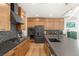 A modern kitchen with wood cabinets, stainless steel appliances, and a large island with dark countertops at 2578 Skylark Trail St, Henderson, NV 89044