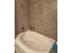 Bathroom with a white bathtub featuring granite-look tile and standard fixtures at 2606 S Durango Dr # 214, Las Vegas, NV 89117