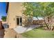 A backyard featuring low-maintenance landscaping, mature trees, a patio, and artificial turf at 305 Napa Hills Dr, Las Vegas, NV 89144