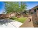 A relaxing backyard featuring low-maintenance landscaping, mature trees, and artificial turf at 305 Napa Hills Dr, Las Vegas, NV 89144