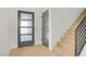 Stylish entryway featuring light wood floors, a modern frosted glass door, and staircase at 305 Napa Hills Dr, Las Vegas, NV 89144