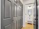 Hallway featuring gray closet doors leading to a bathroom with white vanity and black fixtures at 305 Napa Hills Dr, Las Vegas, NV 89144