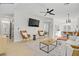 Inviting living room with hardwood floors, ceiling fan, comfortable seating, and seamless flow to the dining area and kitchen at 305 Napa Hills Dr, Las Vegas, NV 89144