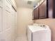 Laundry room featuring a washing machine, a dryer, storage cabinets, and closet at 310 Pissarro Pl, Henderson, NV 89074