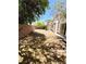 Large backyard with a desert landscape, wood-beam borders, a block wall, and mature trees at 3665 Lucky Horseshoe Ct, Las Vegas, NV 89129