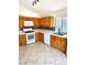Functional kitchen with light wood cabinets, white appliances, and a tiled backsplash, complemented by ceramic tile flooring at 3665 Lucky Horseshoe Ct, Las Vegas, NV 89129