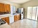Functional kitchen with light wood cabinets, white appliances, and a tiled backsplash, with access to the patio at 3665 Lucky Horseshoe Ct, Las Vegas, NV 89129