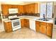 Functional kitchen with light wood cabinets, white appliances, and a tiled backsplash, complemented by ceramic tile flooring at 3665 Lucky Horseshoe Ct, Las Vegas, NV 89129