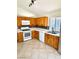 Functional kitchen with light wood cabinets, white appliances, and a tiled backsplash, complemented by ceramic tile flooring at 3665 Lucky Horseshoe Ct, Las Vegas, NV 89129