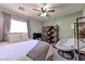 Cozy bedroom with a ceiling fan, a comfortable chair, a bookshelf, and soft natural light from the window at 3823 Aspen Creek Ave, North Las Vegas, NV 89031