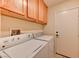 Functional laundry room with washer, dryer, and overhead cabinets at 3823 Aspen Creek Ave, North Las Vegas, NV 89031