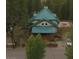 Aerial view showcasing a home with a green metal roof, large deck, and surrounding trees at 4178 Matterhorn Way, Las Vegas, NV 89124