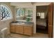 Bathroom with custom windows, vanity with drawers and a view into a bedroom at 4178 Matterhorn Way, Las Vegas, NV 89124