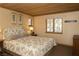 Comfortable bedroom featuring a floral bedspread, wood ceiling and a window bringing in natural light at 4178 Matterhorn Way, Las Vegas, NV 89124
