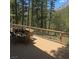 Deck with table and seating with a beautiful view of mountains and tall trees at 4178 Matterhorn Way, Las Vegas, NV 89124